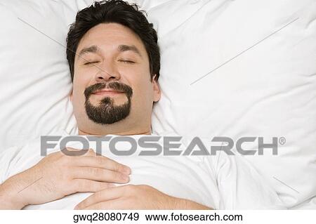 Close-up of a mid adult man sleeping on the bed View Large Photo Image Stock Photo - Close-up of a mid adult man sleeping on the bed. Fotosearch