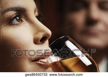 Stock Image - Close-up of a mid adult woman drinking wine. Fotosearch