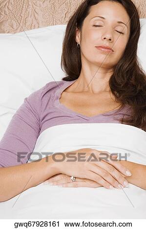 Close-up of a mid adult woman sleeping on the bed View Large Photo Image Stock Image - Close-up of a mid adult woman sleeping on the bed. Fotosearch