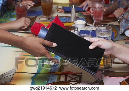 Stock Image - Close-up of a person's hand paying bill by credit card in a restaurant. Fotosearch