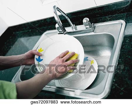 Close-up of a person's hand washing plate in the kitchen View Large Photo Image Stock Image - Close-up of a person's hand washing plate in the kitchen. Fotosearch