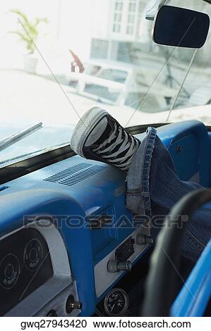 Close-up of a person's leg on the dashboard of a car View Large Photo Image Stock Image - Close-up of a person's leg on the dashboard of a car. Fotosearch