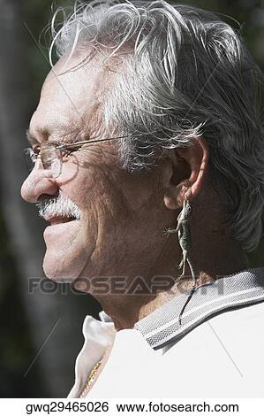 Close-up of a senior man hanging a lizard on his ear View Large Photo Image Stock Photograph - Close-up of a senior man hanging a lizard on his ear. Fotosearch