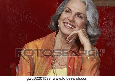 Close-up of a senior woman smiling with her hand on her chin View Large Photo Image Stock Photo - Close-up of a senior woman smiling with her hand on her chin. Fotosearch