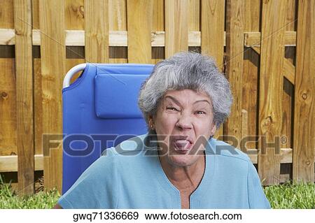 Close-up of a senior woman sticking her tongue out View Large Photo Image Stock Photo - Close-up of a senior woman sticking her tongue out. Fotosearch
