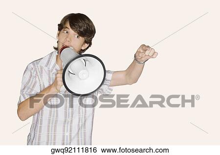 Close-up of a teenage boy blowing a bullhorn and pointing forward View Large Photo Image Stock Photograph - Close-up of a teenage boy blowing a bullhorn and pointing forward. Fotosearch