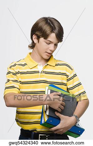 Close-up of a teenage boy holding books and ring binders View Large Photo Image Stock Image - Close-up of a teenage boy holding books and ring binders. Fotosearch