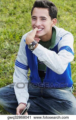 Close-up of a teenage boy smiling with his finger on his mouth View Large Photo Image Stock Image - Close-up of a teenage boy smiling with his finger on his mouth. Fotosearch