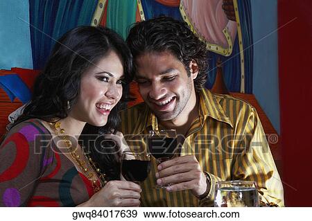 Close-up of a young couple holding glasses of red wine View Large Photo Image Stock Photo - Close-up of a young couple holding glasses of red wine. Fotosearch