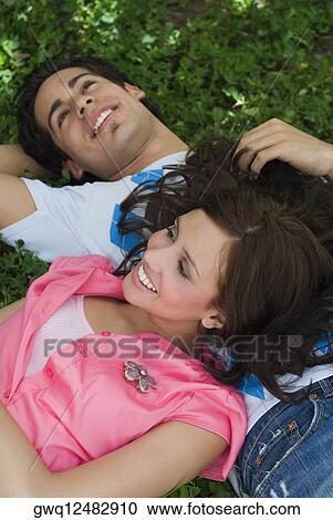 Close-up of a young couple lying in a park View Large Photo Image Stock Image - Close-up of a young couple lying in a park. Fotosearch