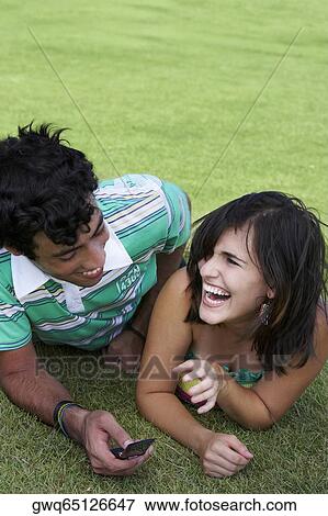 Stock Photo - Close-up of a young couple lying in a lawn and smiling. Fotosearch