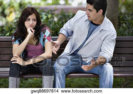 Close-up of a young couple sitting on a park bench View Large Photo Image Picture - Close-up of a young couple sitting on a park bench. Fotosearch