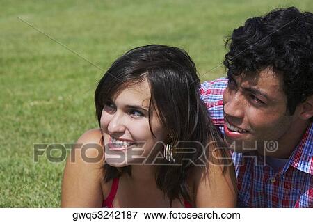Close-up of a young couple smiling and looking away View Large Photo Image Stock Photo - Close-up of a young couple smiling and looking away. Fotosearch