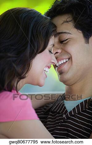 Close-up of a young couple smiling together View Large Photo Image Stock Photography - Close-up of a young couple smiling together. Fotosearch