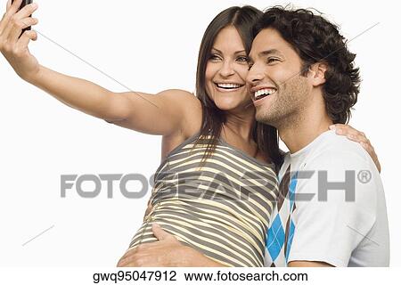 Close-up of a young couple taking a photograph of themselves with a mobile phone View Large Photo Image Stock Image - Close-up of a young couple taking a photograph of themselves with a mobile phone. Fotosearch