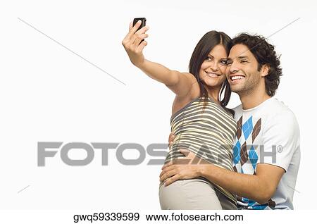 Close-up of a young couple taking a photograph of themselves with a mobile phone View Large Photo Image Stock Photo - Close-up of a young couple taking a photograph of themselves with a mobile phone. Fotosearch
