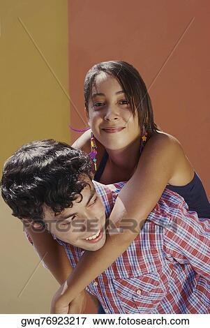 Close-up of a young man giving a piggyback to a young woman View Large Photo Image Stock Photo - Close-up of a young man giving a piggyback to a young woman. Fotosearch