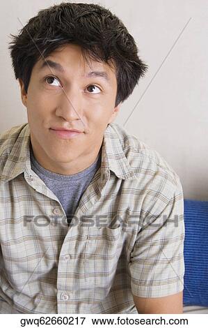 Close-up of a young man looking up View Large Photo Image Stock Photo - Close-up of a young man looking up. Fotosearch