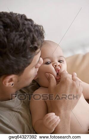 Close-up of a young man playing with his son View Large Photo Image Stock Image - Close-up of a young man playing with his son. Fotosearch