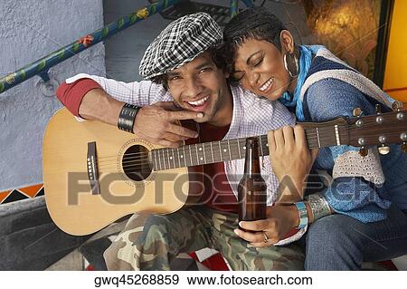Close-up of a young man smiling with a young woman View Large Photo Image Stock Photo - Close-up of a young man smiling with a young woman. Fotosearch
