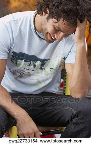 Close-up of a young man smiling with his hand in his hair View Large Photo Image Picture - Close-up of a young man smiling with his hand in his hair. Fotosearch