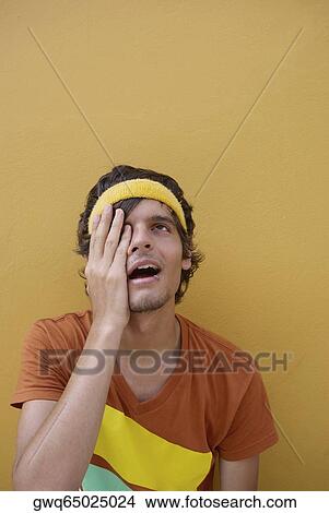 Close-up of a young man with his hand on his eye View Large Photo Image Picture - Close-up of a young man with his hand on his eye. Fotosearch