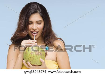 Close-up of a young woman drinking coconut milk and smiling View Large Photo Image Picture - Close-up of a young woman drinking coconut milk and smiling. Fotosearch