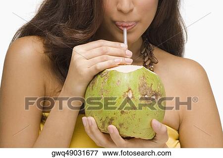 Close-up of a young woman drinking coconut milk View Large Photo Image Stock Photo - Close-up of a young woman drinking coconut milk. Fotosearch