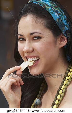 Close-up of a young woman eating potato chips View Large Photo Image Stock Photo - Close-up of a young woman eating potato chips. Fotosearch