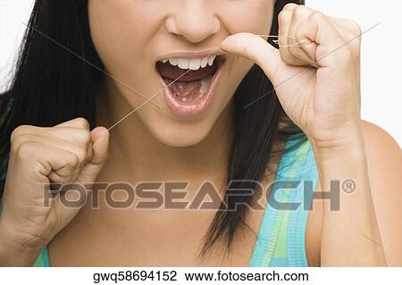 Close-up of a young woman flossing her teeth View Large Photo Image Stock Image - Close-up of a young woman flossing her teeth. Fotosearch