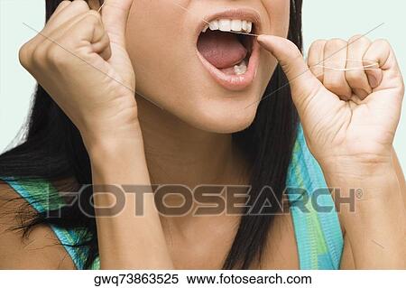 Close-up of a young woman flossing her teeth View Large Photo Image Stock Photography - Close-up of a young woman flossing her teeth. Fotosearch