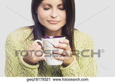 Close-up of a young woman holding a cup of coffee View Large Photo Image Stock Image - Close-up of a young woman holding a cup of coffee. Fotosearch