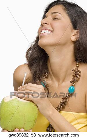 Close-up of a young woman holding a peeled coconut and smiling View Large Photo Image Stock Image - Close-up of a young woman holding a peeled coconut and smiling. Fotosearch