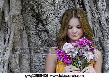 Close-up of a young woman holding a bouquet of flowers View Large Photo Image Stock Photograph - Close-up of a young woman holding a bouquet of flowers. Fotosearch