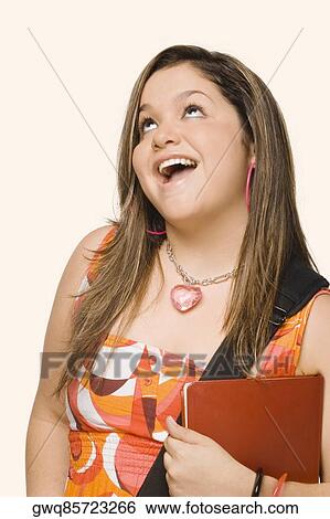 Close-up of a young woman holding a diary and smiling View Large Photo Image Stock Photograph - Close-up of a young woman holding a diary and smiling. Fotosearch