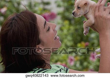 Close-up of a young woman playing with a puppy View Large Photo Image Stock Image - Close-up of a young woman playing with a puppy. Fotosearch