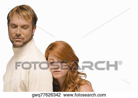 Stock Image - Close-up of a young woman resting her face on the shoulder of a mid adult man. Fotosearch