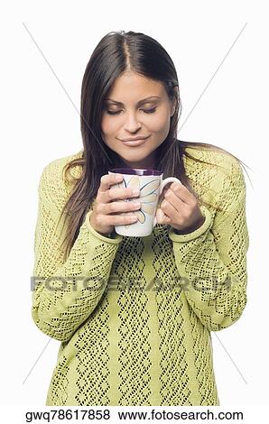 Close-up of a young woman standing and holding a cup of coffee View Large Photo Image Stock Photo - Close-up of a young woman standing and holding a cup of coffee. Fotosearch