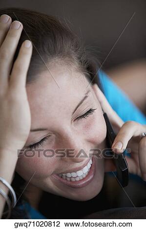 Close-up of a young woman talking on a mobile phone and smiling View Large Photo Image Stock Image - Close-up of a young woman talking on a mobile phone and smiling. Fotosearch