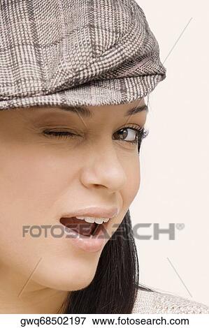 Close-up of a young woman winking View Large Photo Image Stock Photo - Close-up of a young woman winking. Fotosearch