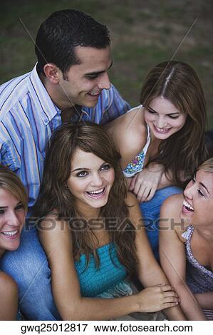 Stock Photo - Close-up of four young women smiling with a young man. Fotosearch