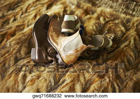 Stock Image - Close-up of pairs of shoes and boots on a blanket. Fotosearch