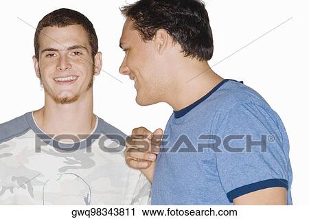 Close-up of two young men talking to each other View Large Photo Image Stock Image - Close-up of two young men talking to each other. Fotosearch