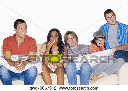 Five friends sitting on a couch and watching television View Large Photo Image Stock Image - Five friends sitting on a couch and watching television. Fotosearch