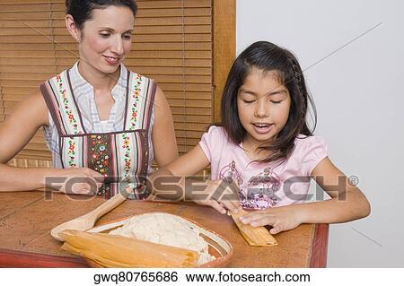 Girl preparing bread with her mother in the kitchen View Large Photo Image Stock Photograph - Girl preparing bread with her mother in the kitchen. Fotosearch