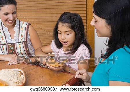 Girl preparing bread with her mother and sister in the kitchen View Large Photo Image Stock Photo - Girl preparing bread with her mother and sister in the kitchen. Fotosearch