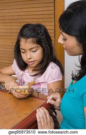 Stock Image - Girl preparing bread with her sister in the kitchen. Fotosearch