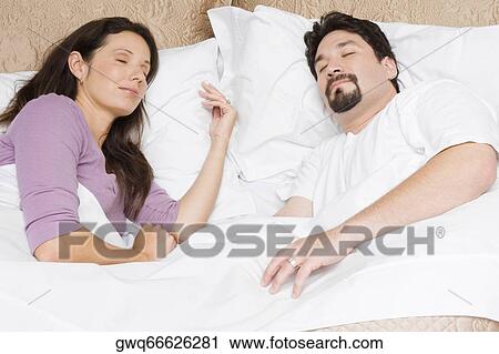 High angle view of a mid adult couple sleeping on the bed View Large Photo Image Stock Image - High angle view of a mid adult couple sleeping on the bed. Fotosearch