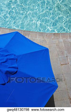 High angle view of a patio umbrella at the poolside View Large Photo Image Stock Photo - High angle view of a patio umbrella at the poolside. Fotosearch