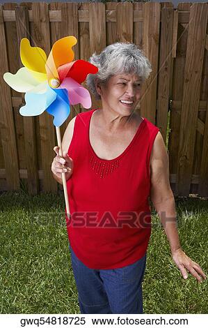 Stock Photography - High angle view of a senior woman holding a pinwheel. Fotosearch